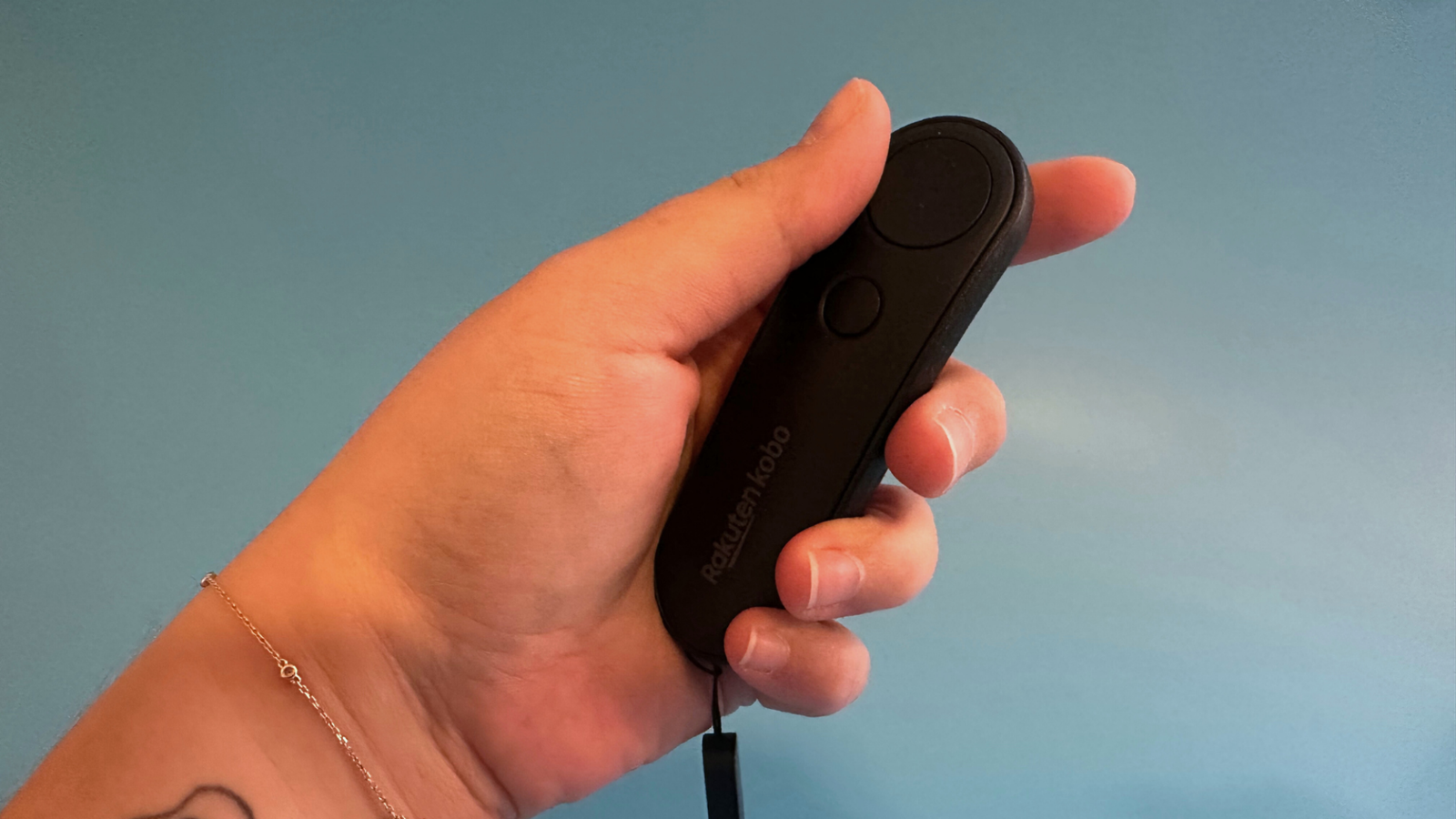 A hand holding the Kobo remote.